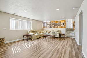 Living area featuring light wood finished floors, recessed lighting, and a textured ceiling