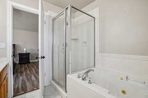 Full bathroom with a shower stall, light marble finish flooring, a tub with jets, and vanity