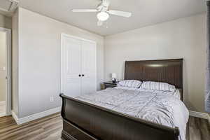 Bedroom with a closet, wood finished floors, and a ceiling fan