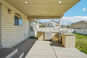 Fenced backyard with area for grilling and a patio