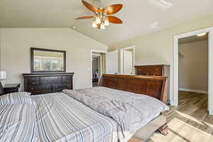 Bedroom featuring a walk in closet, light wood-style floors, and ceiling fan
