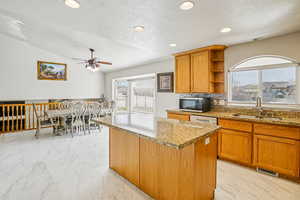 Kitchen featuring light stone counters, recessed lighting, decorative backsplash, open shelves, and wood finish cabinetry
