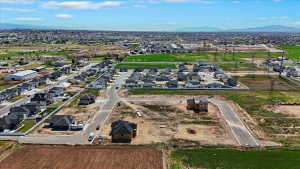 Aerial overview of property's location with nearby suburban area and a mountainous background
