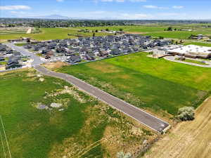 Aerial view of property and surrounding area featuring a mountainous background and nearby suburban area