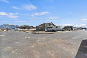 View of asphalt road with sidewalks, a residential view, and curbs