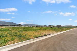 View of asphalt street with curbs, a mountain view, and a residential view
