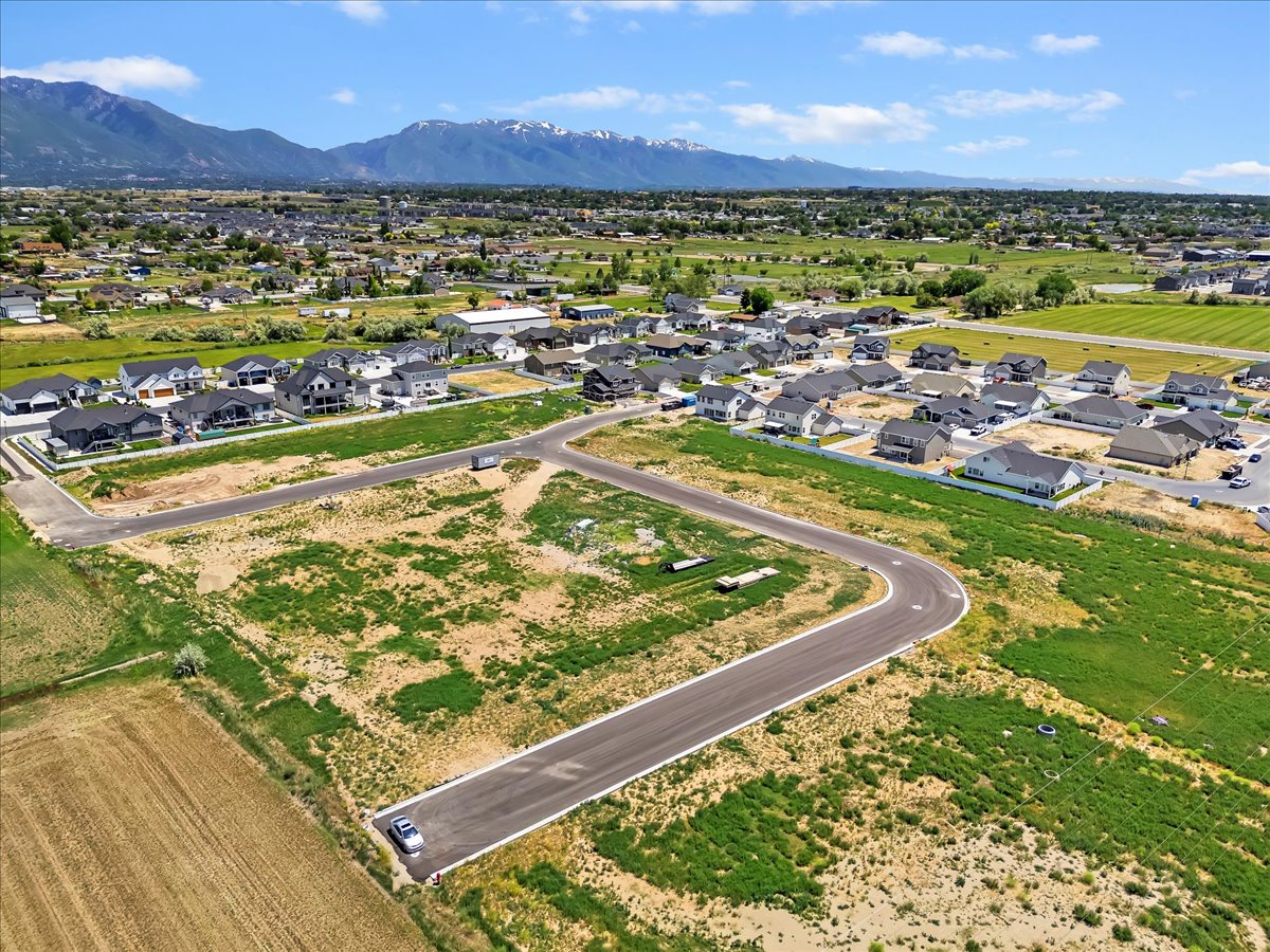 Aerial view of property and surrounding area with a mountain backdrop and nearby suburban area
