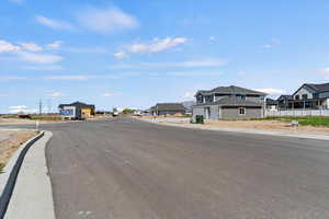 View of asphalt street featuring curbs and a residential view