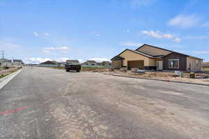 View of asphalt road featuring a residential view and curbs