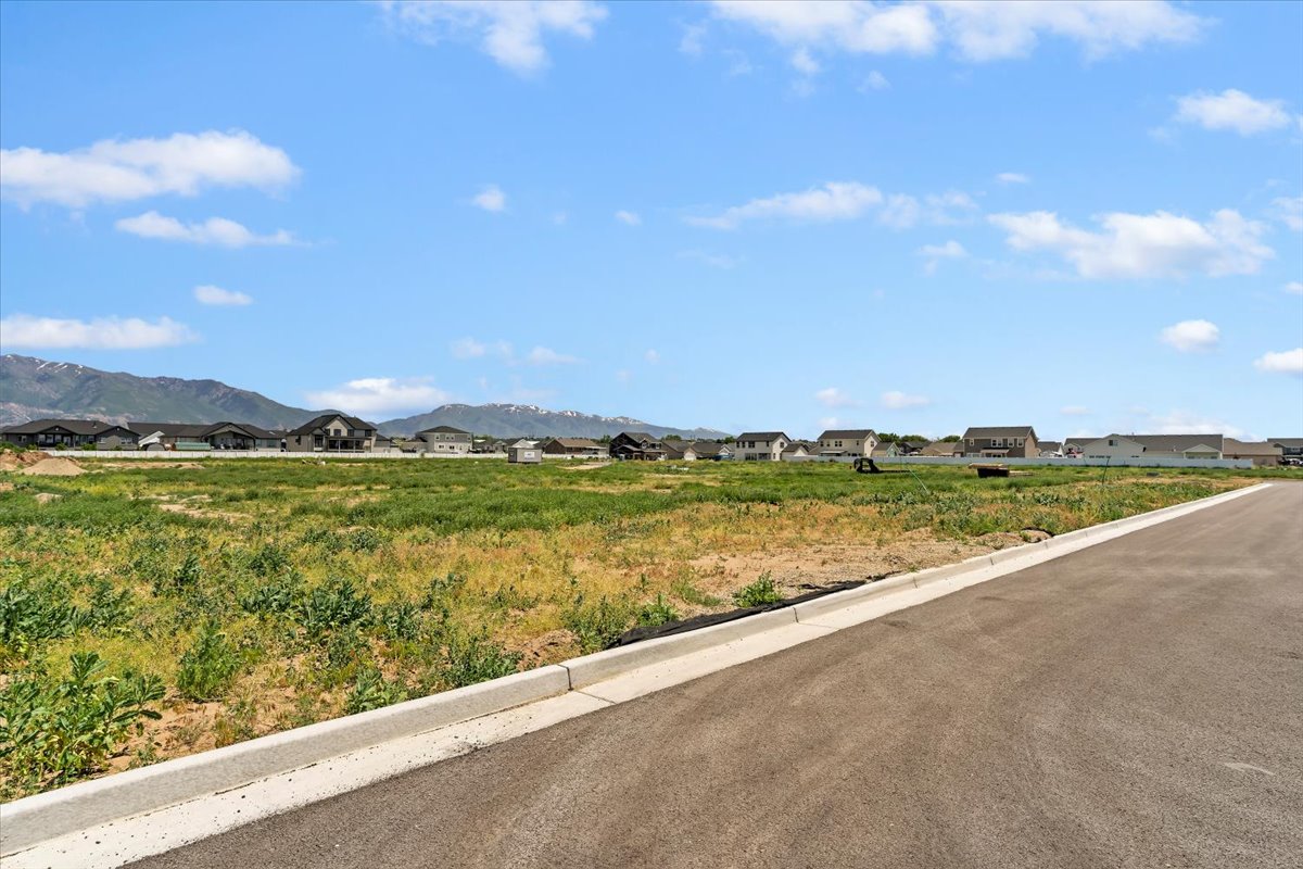 View of asphalt street with curbs, a mountain view, and a residential view