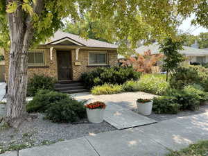 View of front of home featuring a shingled roof and brick siding