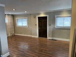 Foyer entrance with dark wood-style floors and baseboards