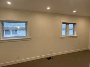 Empty room featuring recessed lighting and dark carpet