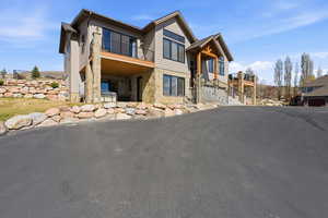 View of front of home featuring a patio and stone siding