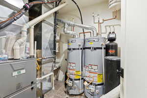 Utility room featuring heating unit and water heater