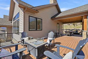 Wooden terrace featuring outdoor dining space and an outdoor fire pit