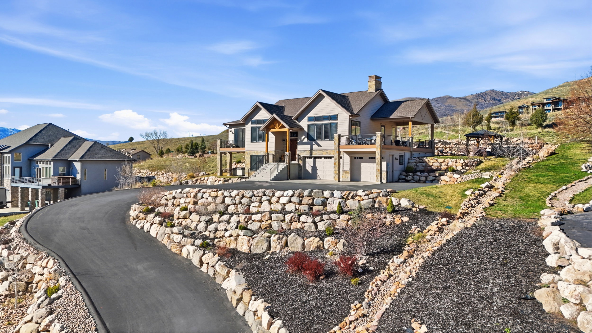 View of front of house with an attached garage, a chimney, a balcony, and a mountain view