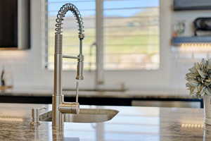 Kitchen view of light stone countertops and a sink
