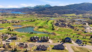 Aerial view of residential area featuring a water and mountain view and a golf course