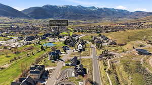 Aerial view of property and surrounding area with a water and mountain view and nearby suburban area