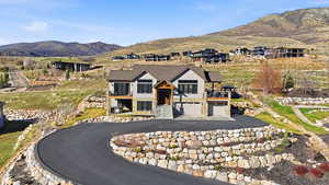 View of front facade with a mountain view, an attached garage, and asphalt driveway