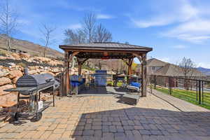 View of patio / terrace featuring a gazebo, grilling area, a mountain view, and an outdoor living space