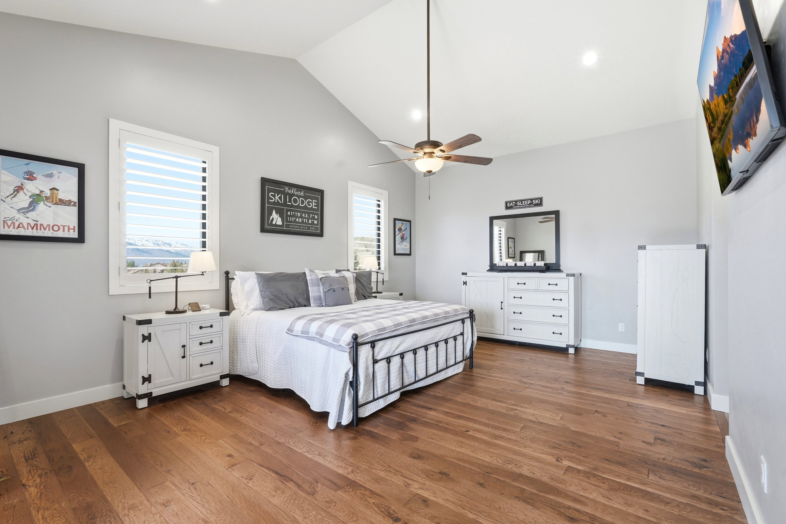 Bedroom with vaulted ceiling, dark wood-style floors, ceiling fan, multiple windows, and recessed lighting