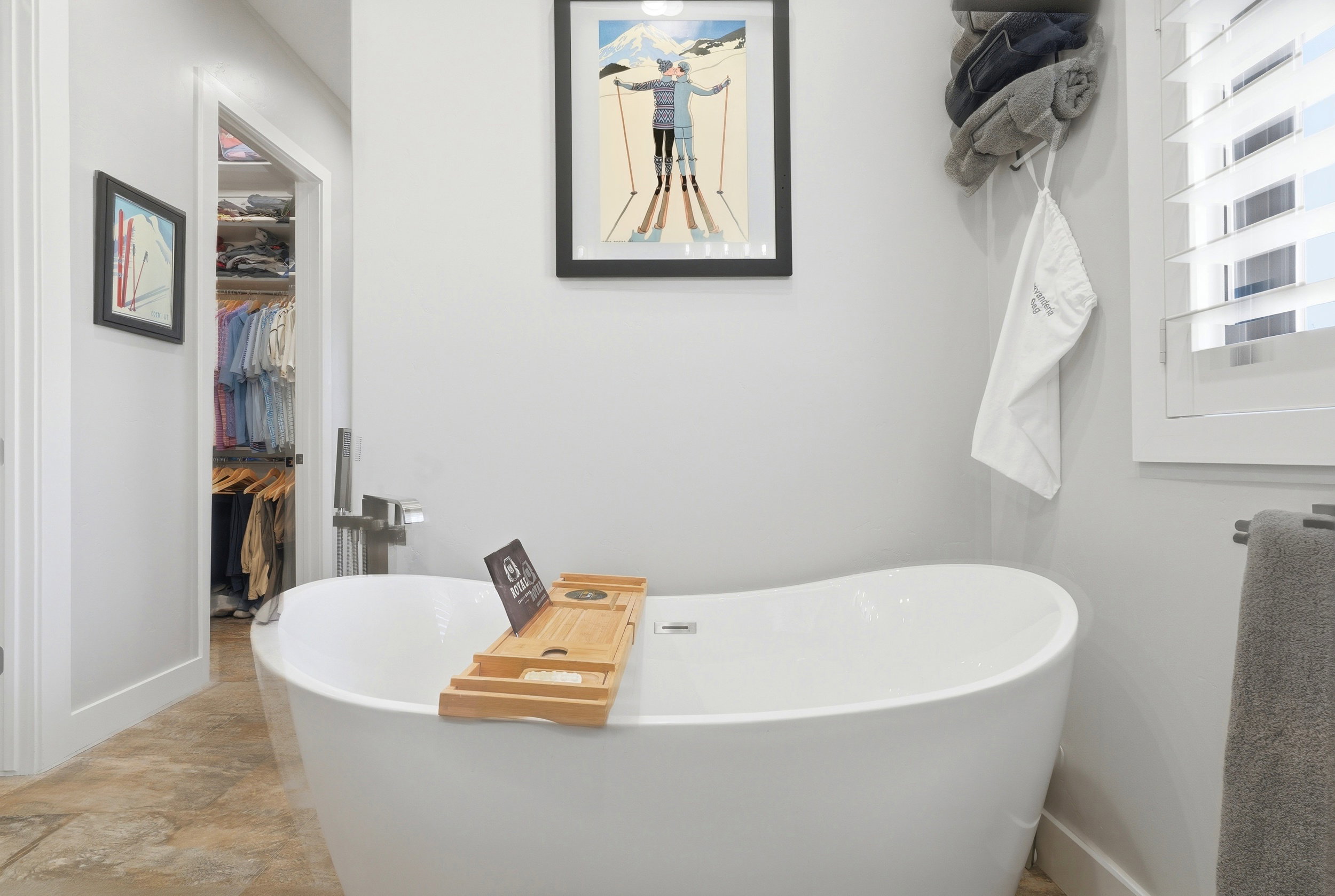 Bathroom with a soaking tub and a walk in closet