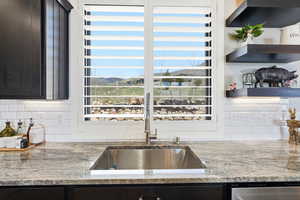 Kitchen featuring light stone countertops, tasteful backsplash, a mountain view, and open shelves