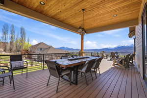 Deck with a mountain view and outdoor dining area