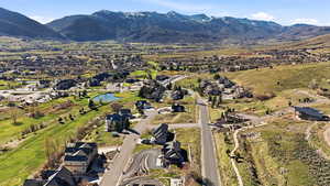 Aerial view of property and surrounding area featuring a water and mountain view and nearby suburban area