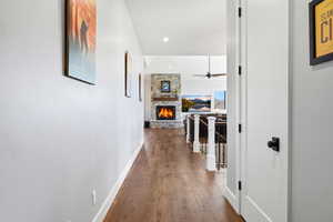 Hall with dark wood-style floors, an upstairs landing, and recessed lighting
