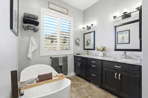 Bathroom featuring double vanity and a soaking tub