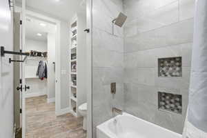 Bathroom featuring a spacious closet, built in features, shower / tub combo with curtain, and recessed lighting