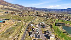 Aerial view of property and surrounding area with nearby suburban area and a water and mountain view