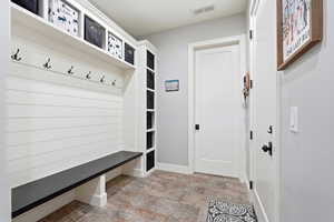 Mudroom featuring stone finish floors and baseboards