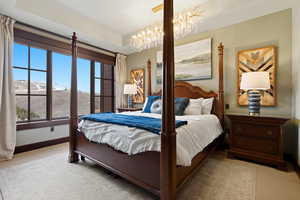 Bedroom featuring a mountain view, light carpet, and a chandelier