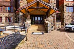 View of exterior entry featuring french doors and stone siding