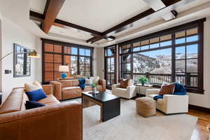 Living room with a mountain view, coffered ceiling, and wood finished floors