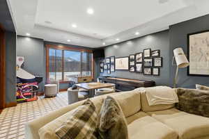 Carpeted living room featuring a raised ceiling and recessed lighting