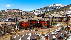 Snowy aerial view featuring a mountain view and a residential view