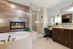 Full bath featuring vanity, a tile fireplace, walk in shower, a bath, and light tile patterned floors