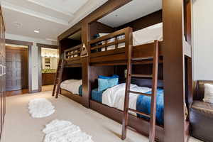 Bedroom with light colored carpet and connected bathroom