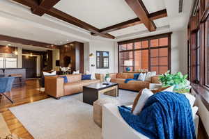 Living area with coffered ceiling and wood finished floors