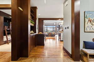 Hall with light wood finished floors and recessed lighting