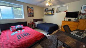 Carpeted bedroom with a ceiling fan