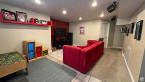 Home theater room with light colored carpet, a textured ceiling, recessed lighting, and light tile patterned flooring