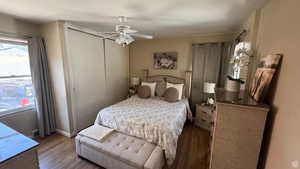 Bedroom with dark wood finished floors, a closet, and ceiling fan