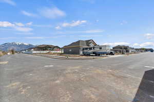 View of asphalt road with sidewalks, a residential view, and curbs