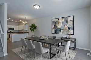 Dining space featuring suspended lighting and dark wood finished floors